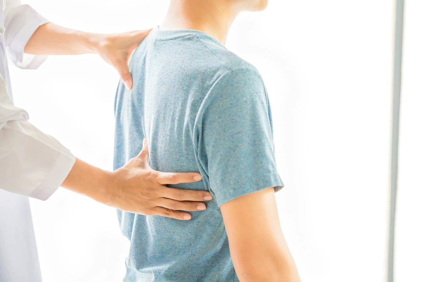 Fisioterapeuta analizando la espalda de un paciente joven